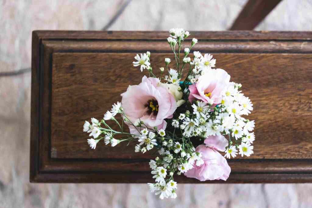 pink floral arrangment on wooden casket.