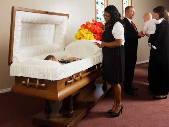 woman visiting an open casket.