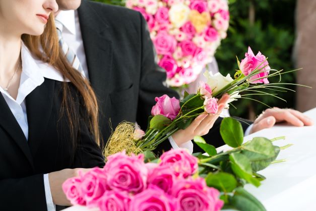 Woman bringing flowers to funeral.