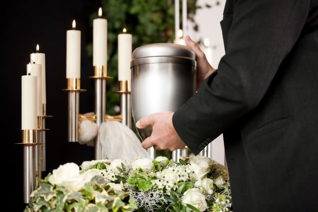 Person holding urn at a memorial service.