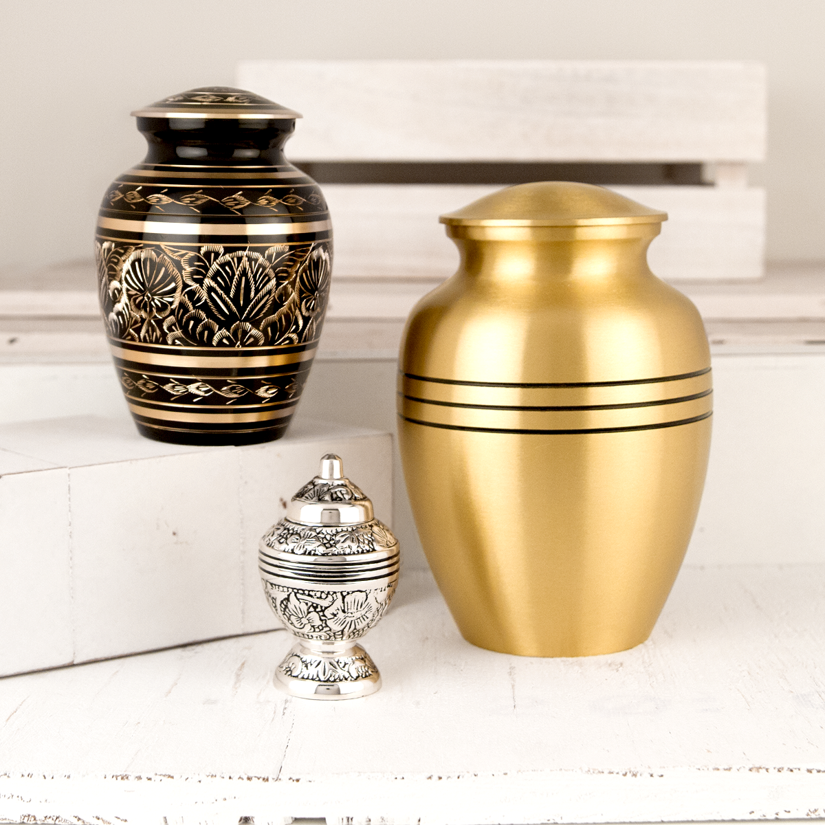 various sizes of metal cremation urns.